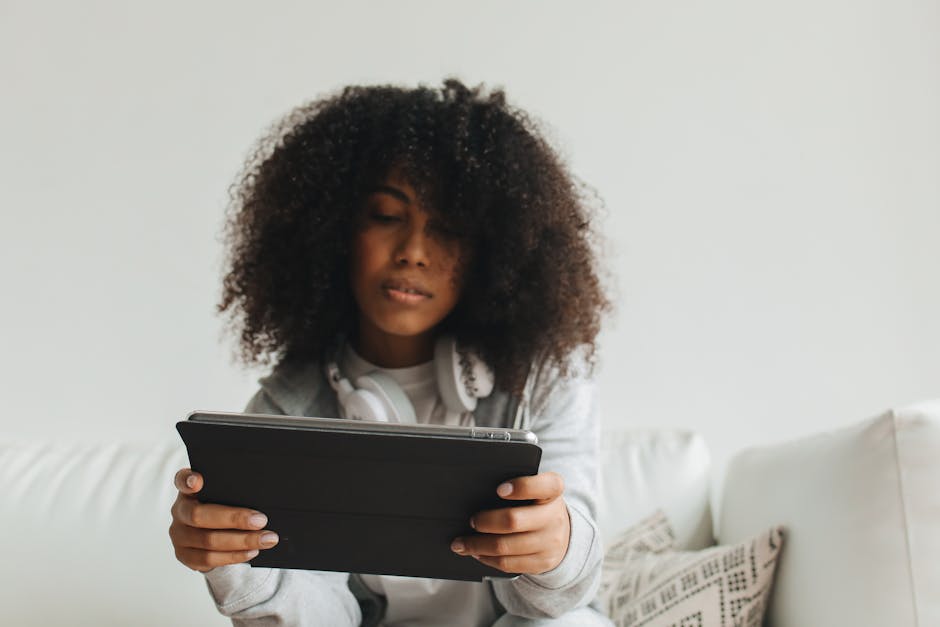 A mature woman reading an article on a tablet in a comfortable living room.